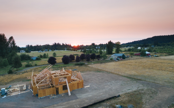 Sunset over a new home construction site in a rural setting.