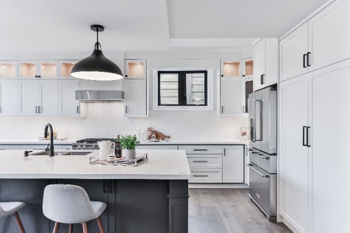 Bright contemporary kitchen with white cabinetry, stainless steel appliances, and a large pendant light