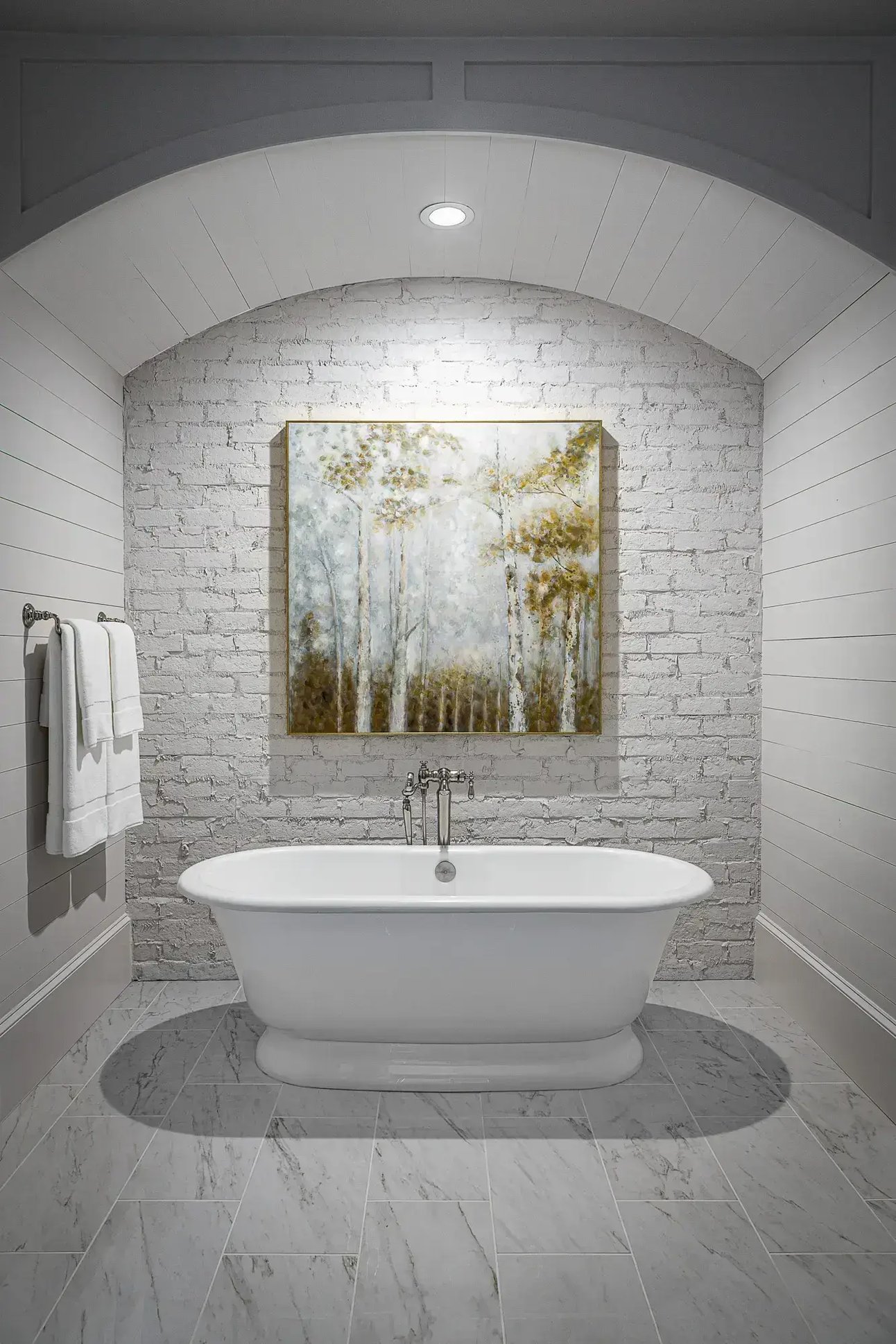 Chic bathroom featuring a freestanding tub against a white brick wall, designed by Michael James Remodeling.