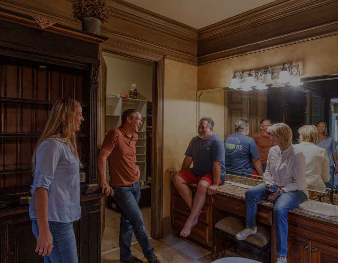 Group of people enjoying a casual gathering in a home with classic decor.