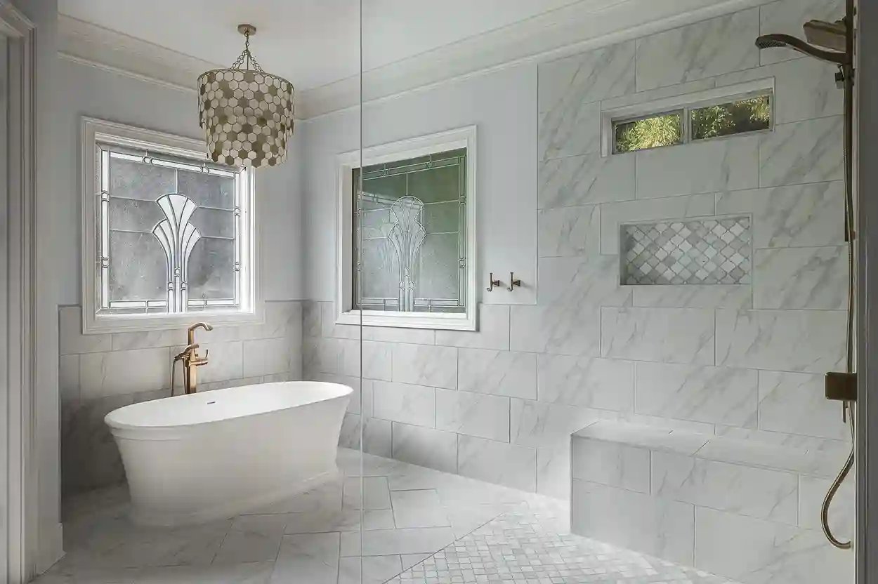 Luxury bathroom with freestanding tub, marble walls, and ornate stained glass window.