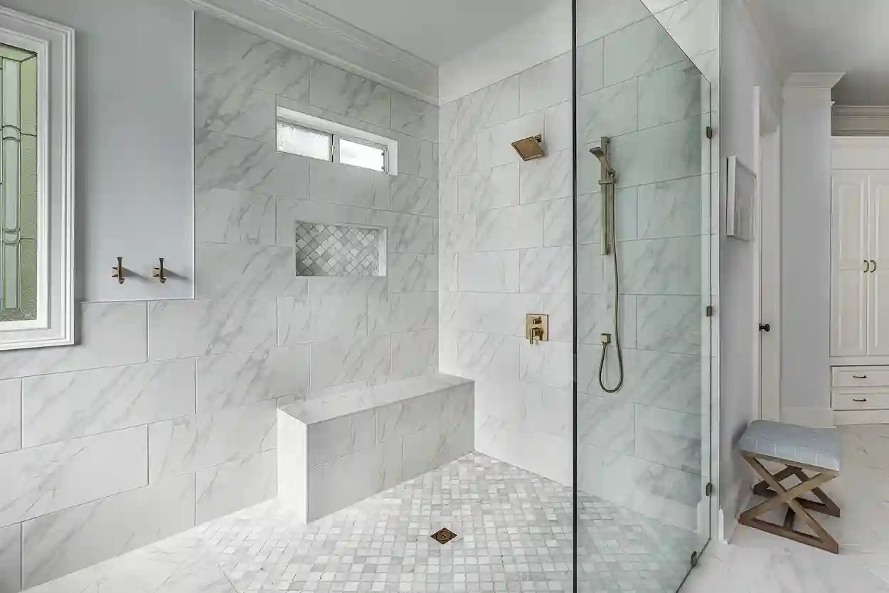 Luxury marble bathroom with glass shower and freestanding tub in natural light