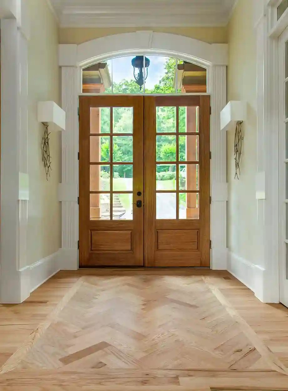 Elegant wooden double entry doors with transom window in a bright entryway
