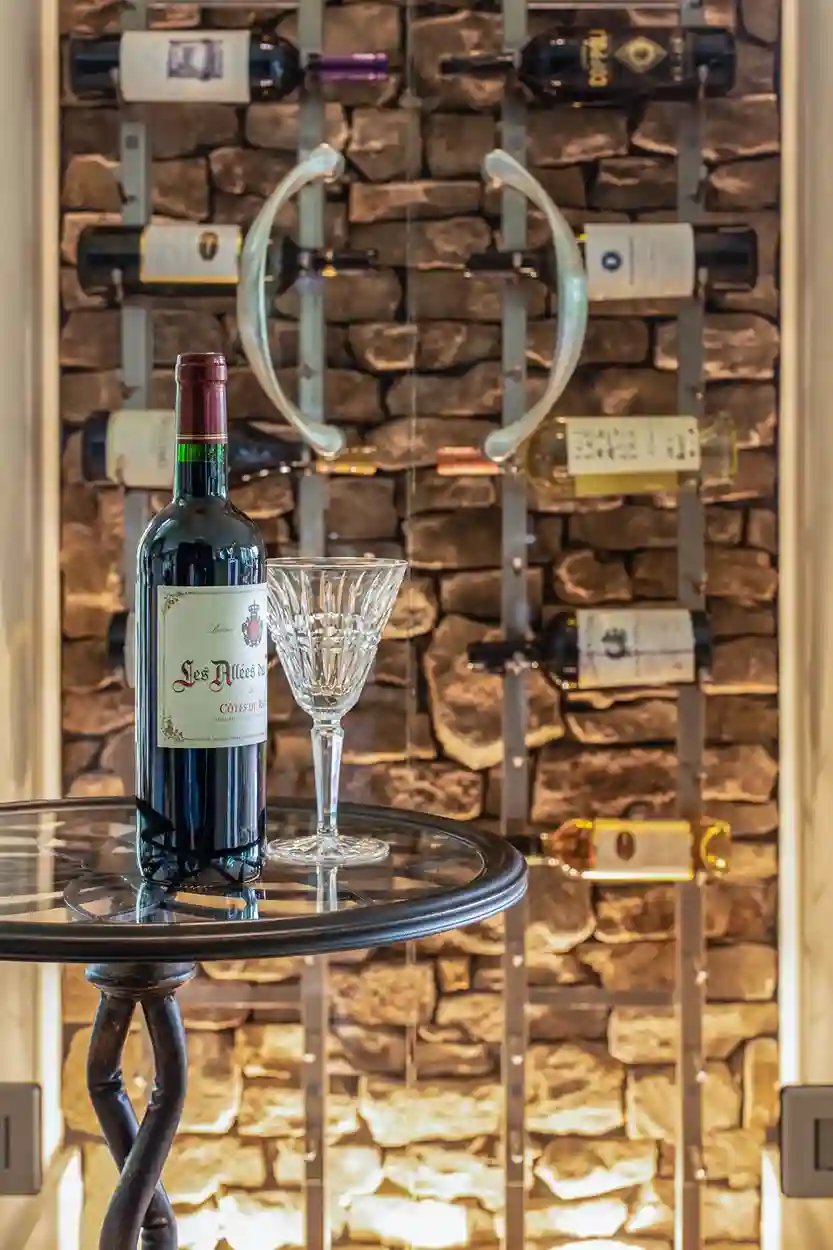 Custom wine storage with stone backdrop and elegant display table by Michael James Remodeling.