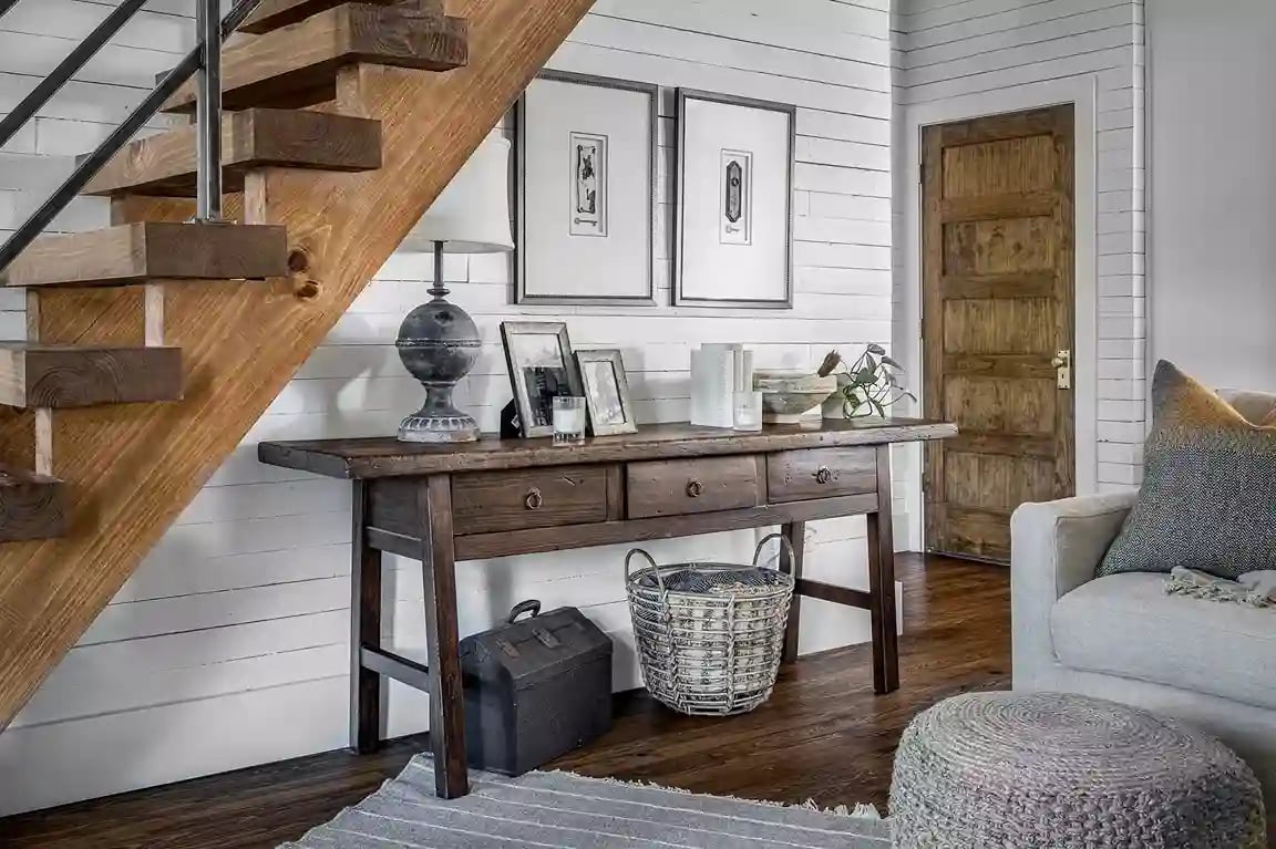 Under-stair nook with rustic wood desk, framed art, and wicker basket