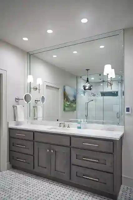 Modern bathroom with double vanity, wall-mounted faucets, and glass shower enclosure.