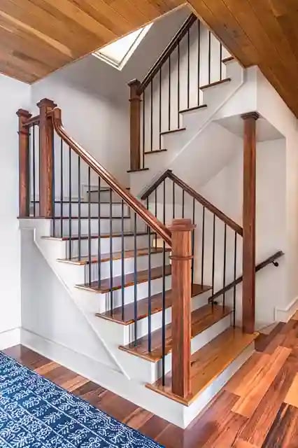 Elegant wooden staircase with wrought iron balusters and hardwood flooring.