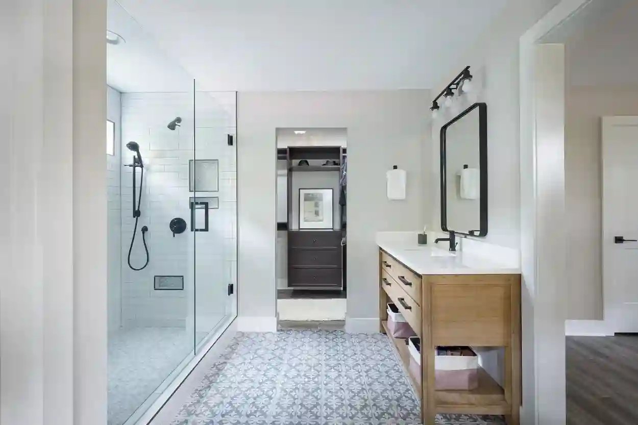 Contemporary bathroom with walk-in shower, patterned floor, and wooden vanity.