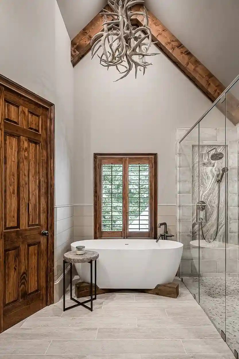 Luxurious bathroom with a freestanding tub, glass shower, and wooden accents under a vaulted ceiling