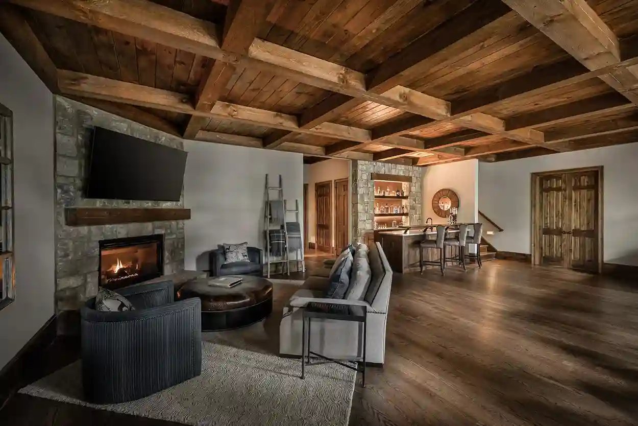 Spacious living room with stone fireplace, exposed beams, and rustic decor