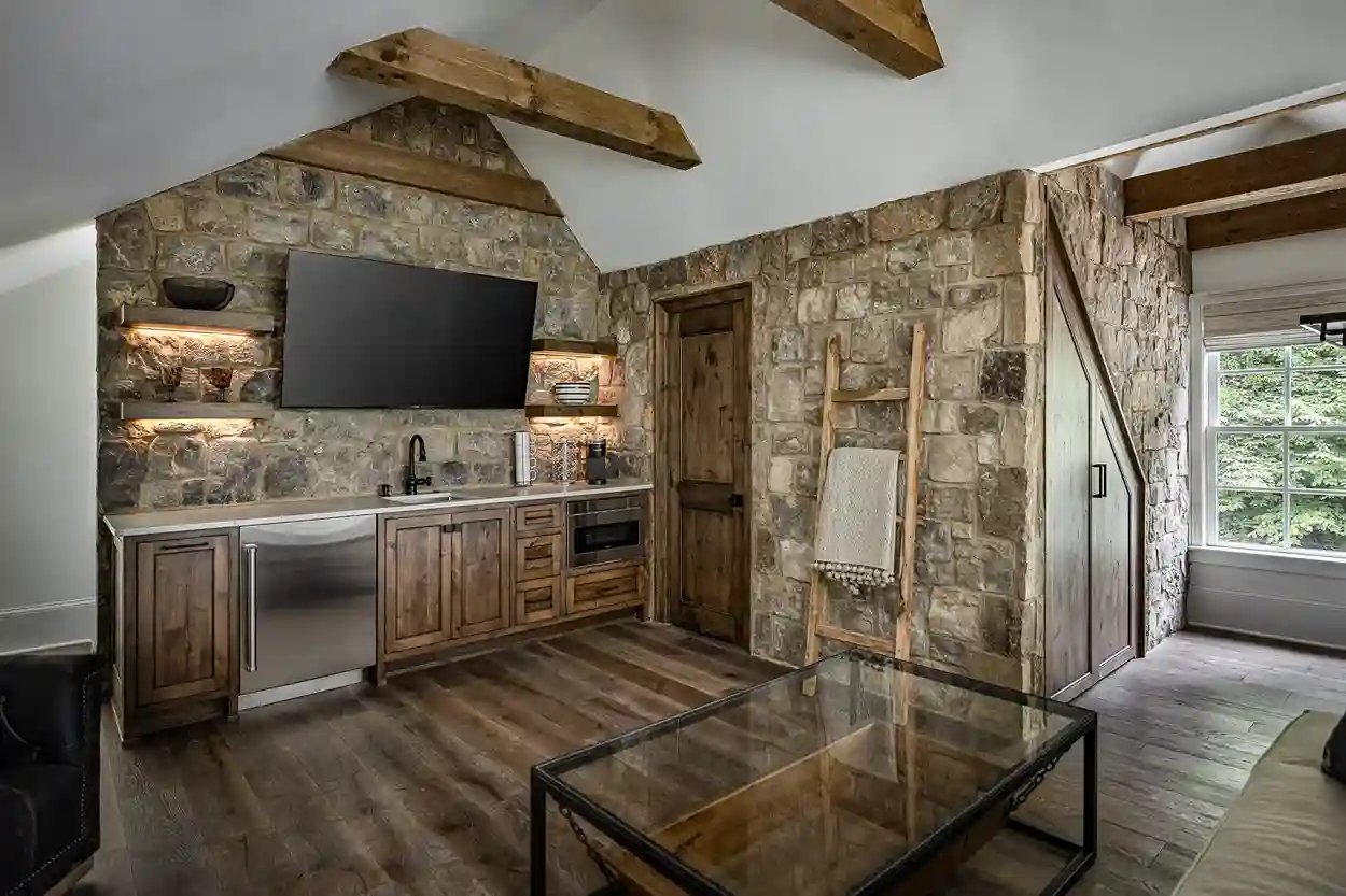 Rustic stone wall entertainment area with wooden beams and built-in cabinetry