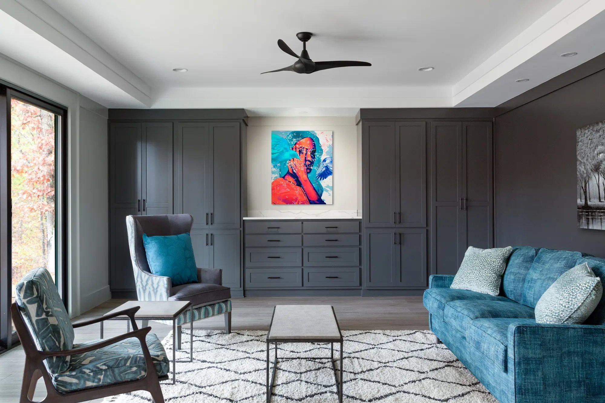 Contemporary living room with blue velvet sofa, abstract art, and custom gray cabinetry