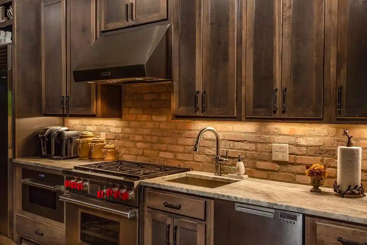 Chic kitchen with dark wood cabinets, stainless steel appliances, and exposed brick backsplash