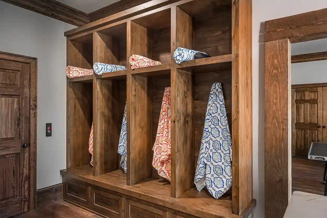 Custom wooden cubby storage with patterned towels in a rustic interior design setting