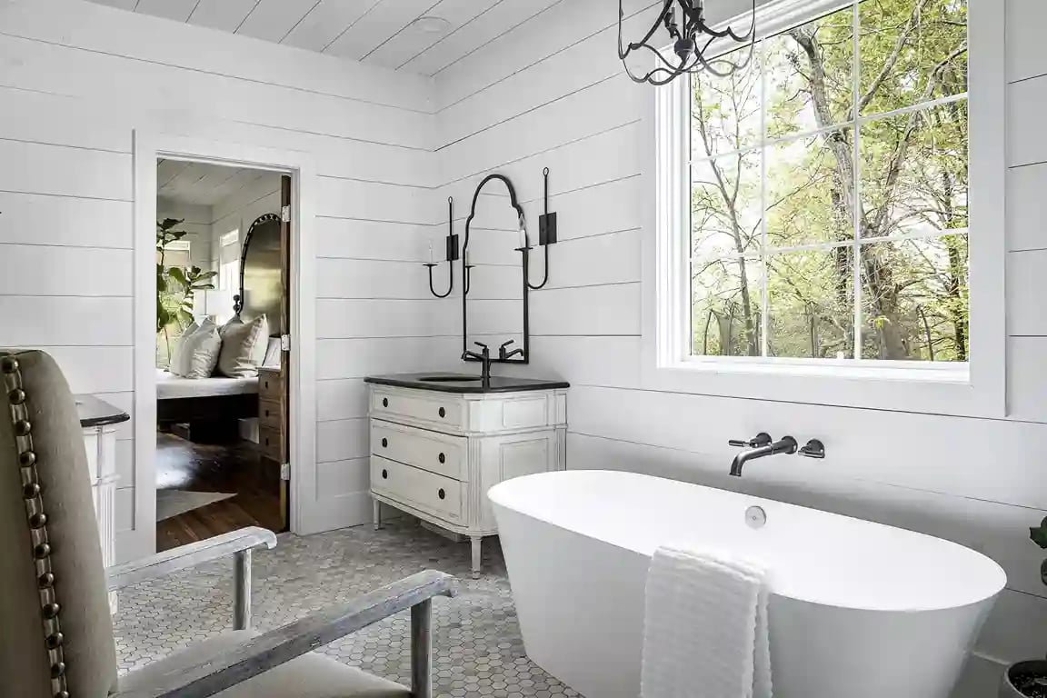 Elegant white bathroom with freestanding tub and vintage vanity designed by Michael James Remodeling.