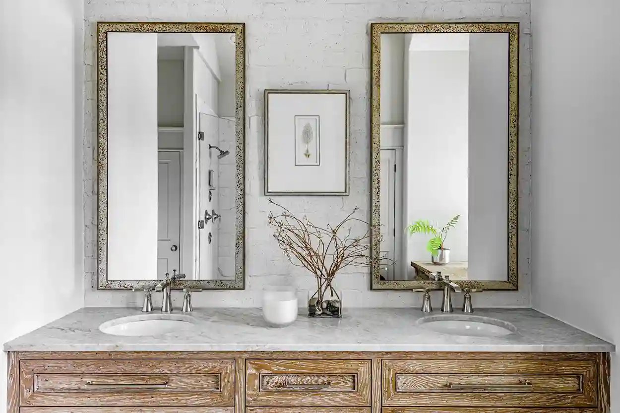 Contemporary bathroom with double vanity, antique mirrors, and white marble countertop