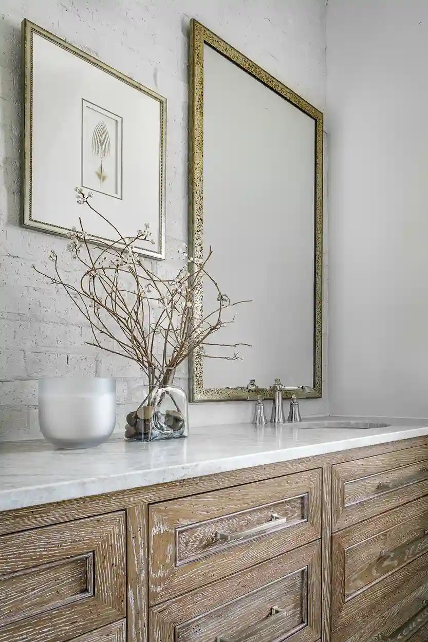 Modern farmhouse bathroom with weathered wood vanity, marble top, and framed wall art.