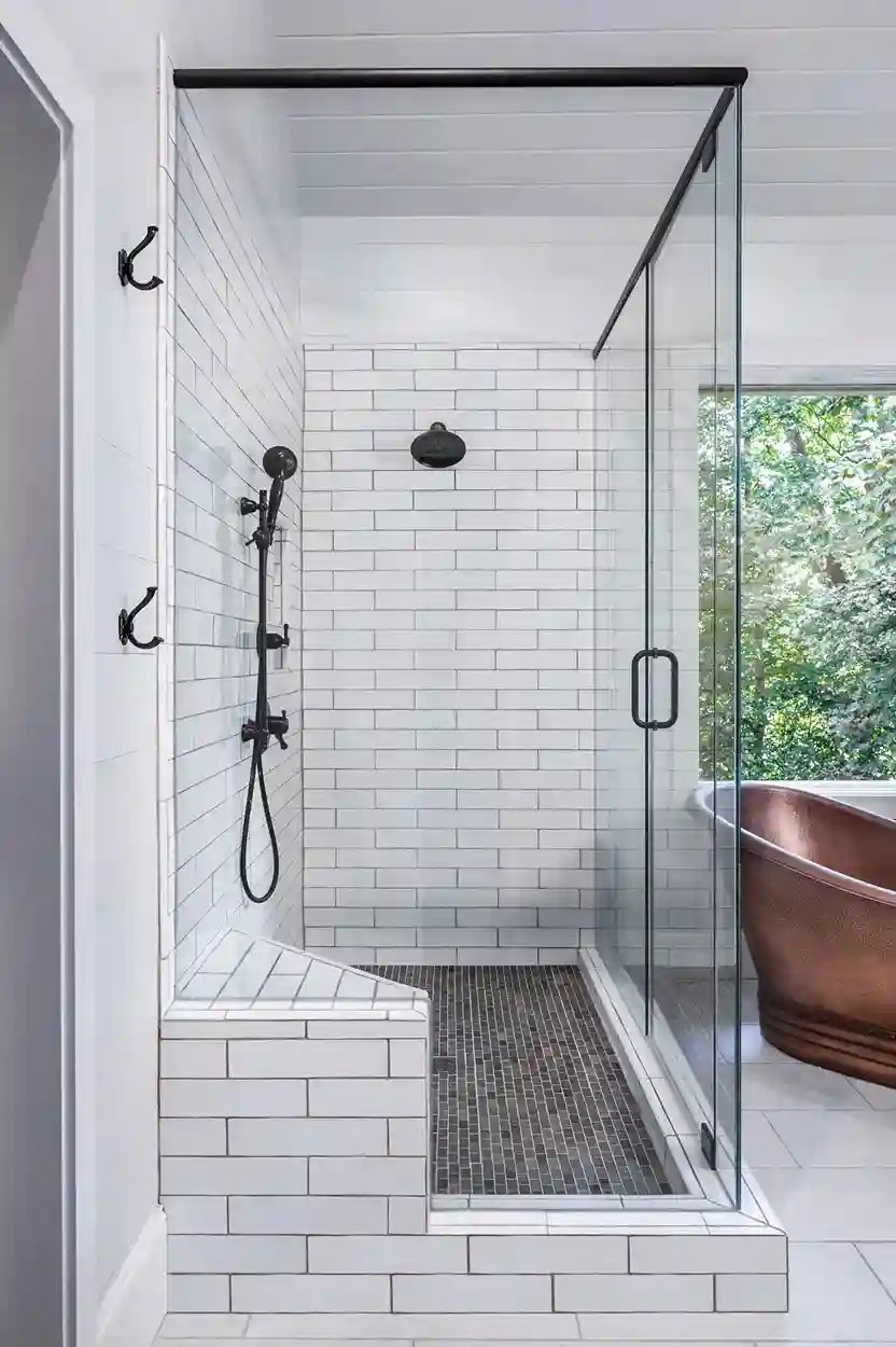 Modern white subway tiled walk-in shower with black fixtures and a view of a freestanding copper bathtub.