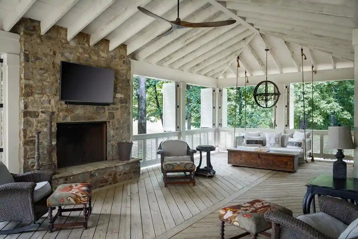 Spacious screened porch with stone fireplace, vaulted ceiling, and comfortable lounge area