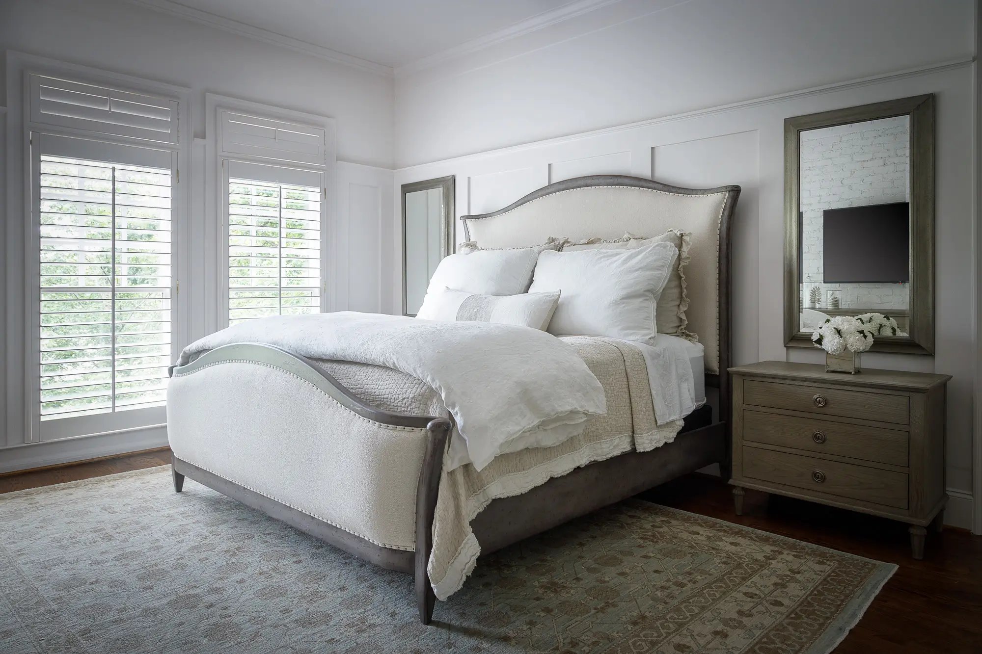 Elegant bedroom with a luxurious bed, plantation shutters, and serene neutral tones.