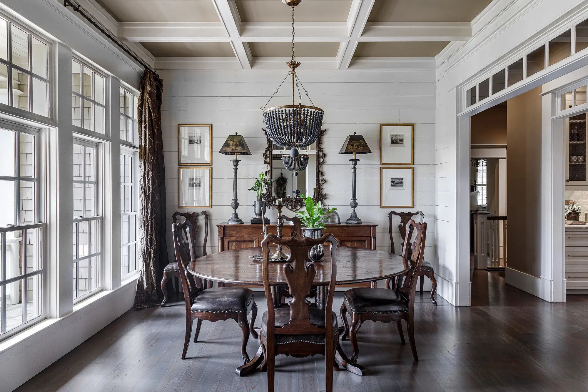 Elegant dining room with classic wooden table and chairs, sophisticated sideboard, and unique chandelier lighting