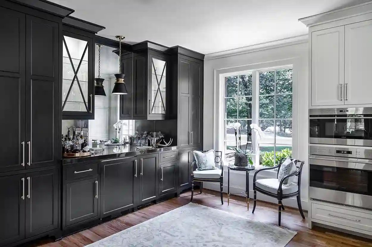 Elegant kitchen with dark cabinets, glass pendants, and a cozy seating area by the window.