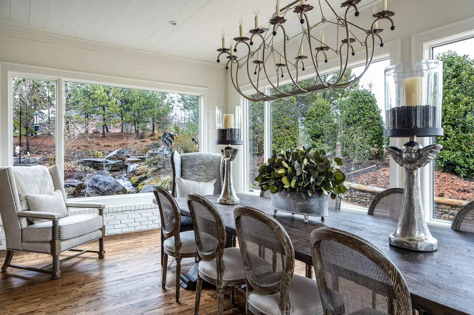 Bright dining area with elegant decor, overlooking a tranquil garden with a water feature