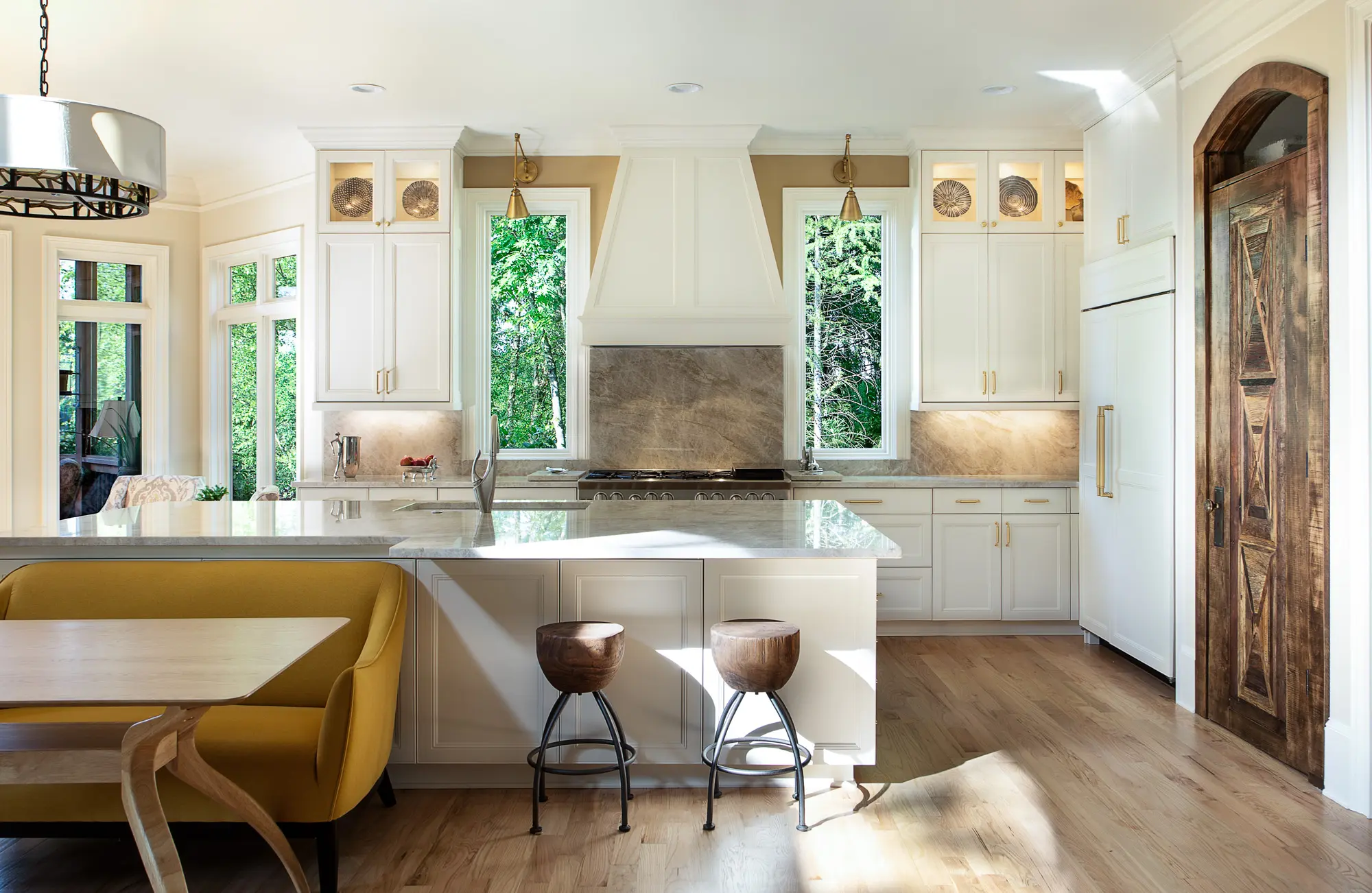 Bright contemporary kitchen remodel with white cabinetry and marble countertops by Michael James Remodeling.