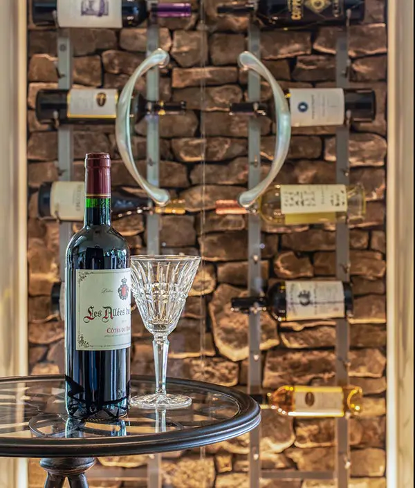 Custom wine storage with stone backdrop and elegant display table by Michael James Remodeling.