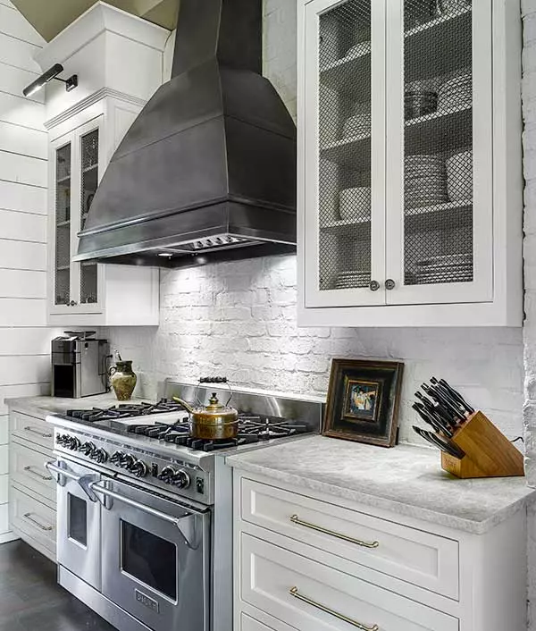 Modern farmhouse kitchen with white shiplap walls and stainless steel range by Michael James Remodeling.